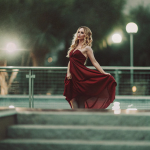 Hayden Panettiere, blonde locks, fair skin, in a flowing red dress. Poses elegantly at the gala event. Soft lighting, dark backdrop