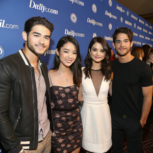 Cody Christian, Arden Cho, Shelley Hennig, and Tyler Posey posing together at a press conference. The backdrop displays the DailyMail.com logo. Event attendees and photographers in the background.