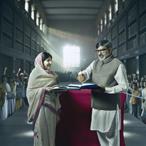 Malala Yousafzai and Kailash Satyarthi during a book signing event. The venue is a bustling library filled with bookshelves and a crowd of eager fans.