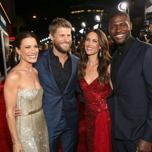Rhona Mitra, Travis Van Winkle, Marissa Neitling, and Jocko Sims at a glitzy Hollywood premiere. They wear glamorous evening wear and beam happily at the cameras.