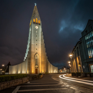 Photograph of Hallgrimskirkja at night in Reykjavik, Iceland. Church lit up against the dark sky.