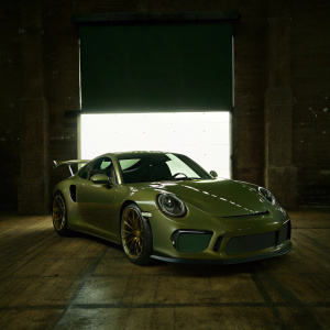 Digital 3D render of matte gray Porsche GT3 RS, standing out with its bold angular rear wing and signature front end design. Set against a plain white backdrop, highlighting the sleek, high-performance features and aggressive styling.
