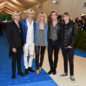 The R5 band members, Riker Lynch, Rydel Lynch, Ross Lynch, Ellington Lee Ratliff, and Rocky Lynch, on the blue carpet at a fashion gala. Wearing casual chic outfits.