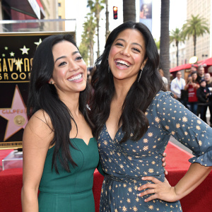 Aimee Garcia and Gina Rodriguez, both with long dark hair, posing joyfully at the Hollywood Walk of Fame unveiling event.