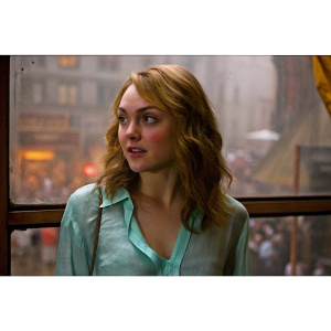 AnnaSophia Robb in a candid photo shoot. Wearing a mint green blouse. Blurry urban background