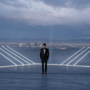 Niall Horan at the Billboard Music Awards, in a black tuxedo. Backdrop of neon lights and Las Vegas skyline.