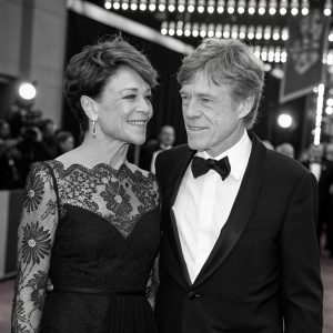 Robert Redford and Sibylle Szaggars Redford, in elegant attire, attending an awards ceremony. Black and white dress, intricate lace detailing, red carpet event.