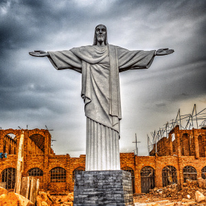 Imposing statue of Jesus Christ in the dark and gritty world of God of War 3. Detailed, black and white