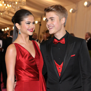 Selena Gomez and Justin Bieber at the Met Gala. Selena in a red velvet dress, Justin in a black tuxedo with red bowtie.