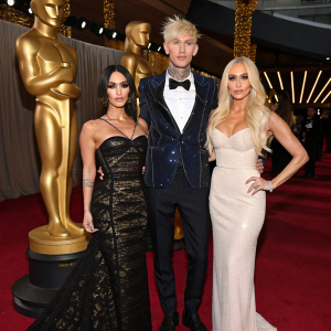 Megan Fox, Machine Gun Kelly, Nats Getty, and Gigi Gorgeous at a Hollywood gala. Golden statues and red carpet backdrop.