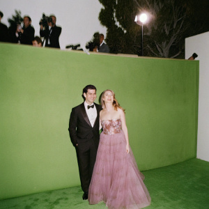 Ty Burrell and Holly Burrell, glamorous couple, standing on a red carpet at the Screen Actors Guild Awards. Ty in black tuxedo, bow-tie; Holly in strapless floral gown with tulle. Photo