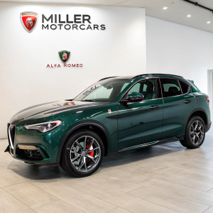 A dark green Alfa Romeo Stelvio SUV displayed prominently at Miller Motorcars showroom. Miller Motorcars logo in bold in the background.