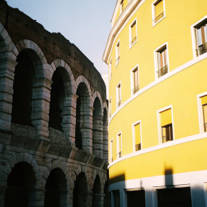 The Verona Arena, an ancient Roman amphitheater. Located in Verona, Italy. Stone structure with arches, surrounded by modern buildings.