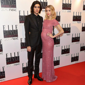 Thomas Cohen and Peaches Geldof at the annual Elle Style Awards. Cohen in a black suit, Geldof in a sparkling pink dress. They stand confidently on a red carpet adorned with Elle Style Awards logos.