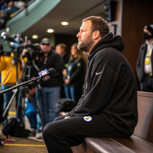 Ben Roethlisberger, quarterback, wearing black hoodie and sweatpants. Sitting on a bench during a press conference.