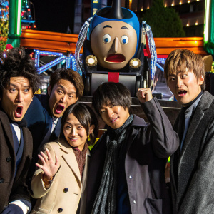 Promotional image for Detective Conan Movie 5 featuring a diverse cast of characters from the anime series. The group poses with various expressions against a colorful backdrop.