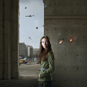 Malka Ru in a vibrant comic book scene. Long brown hair, serious expression. Surrounded by dynamic action elements.