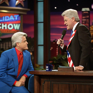 Jay Leno interviewing Phil Hartman, dressed as Bill Clinton, on a talk show set.