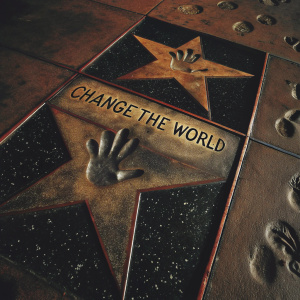 A black and white photo of Will Smith's handprints on the Hollywood Walk of Fame. The star features the phrase 'Change the World' etched in stone.