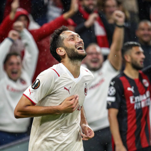 Hakan Çalhanoğlu, midfield wizard, post-goal celebration. Tifosy in the background, red and white jerseys. Drenched in sweat, beaming with joy.