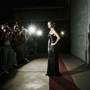 Gal Gadot, in elegant evening gown, at glamorous awards ceremony. Bright lights, red carpet, crowd of photographers and fans.