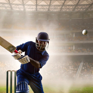 Mahela Jayawardene, Sri Lankan cricketer, intense focus, batting stance. Dark blue uniform, helmet. Cricket ball in motion. Crowd and ads blurred. Sports action shot.