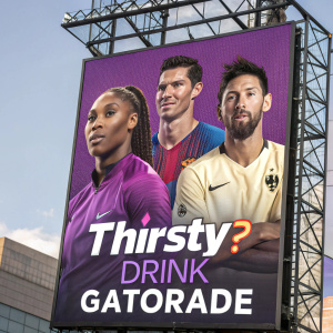Digital billboard featuring Serena Williams, Cristiano Ronaldo, and Lionel Messi alongside Gatorade's slogan. A vivid purple backdrop with the Gatorade logo prominently displayed.