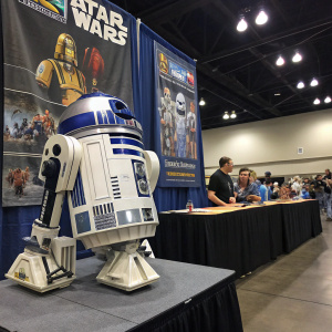 An indoor shot of a R2-D2 replica, blue and white, displayed at a Star Wars fan convention.