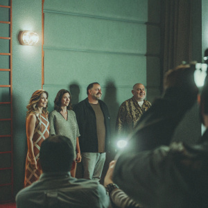 Edie Falco, Robert Iler, Jamie-Lynn Sigler, and James Gandolfini at the premiere of a new film. They stand together, posing for photographers against a bright, colorful backdrop.