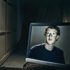 Close-up of Mark Zuckerberg's face on a computer screen. The dark background contrasts sharply with his image.