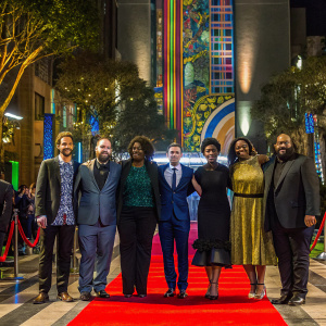 Aaron Nee, Adam Nee, Liza Chasin, Sandra Bullock, Daniel Radcliffe, Da'Vine Joy Randolph, and Patti Harrison on a red carpet event. The backdrop features vibrant colors and intricate designs.