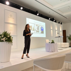 Virginia Carbajal presenting her brand identity design at a sleek, modern conference. Clean white backdrop