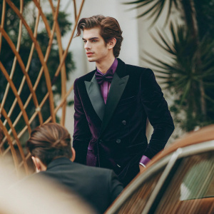 Andrew Garfield in a sleek black suit with purple accents. At the Golden Globe Awards. Focused pose, modern backdrop with intricate gold details.