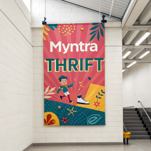 A vibrant banner for Myntra Thrift hangs on a white wall, advertising a huge sale.