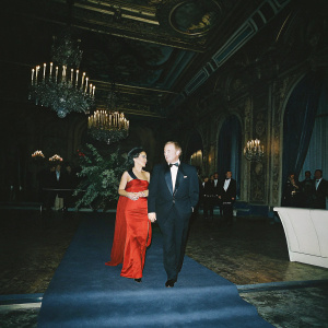 Salma Hayek and Francois-Henri Pinault attending a glamorous charity gala. Lavish venue with chandeliers and gold accents.