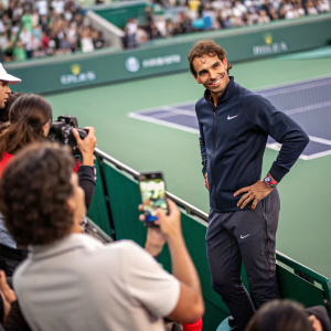 Rafael Nadal, tennis star, posing for interview. Courtside with fans in background.