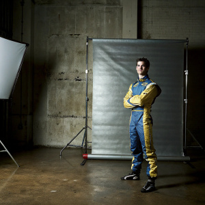 Alexander Rossi in a sleek racing outfit. White studio backdrop. Sporty pose.