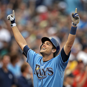 Matt Moore, Tampa Bay Rays player, celebrating home run. In blue jersey and cap, raising arms. Crowd blurred in background, shallow depth of field