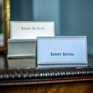 Two business cards, teal background, 'Johan du Ploit' on top, 'Barry Botha' below, stacked neatly