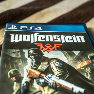 Dark and action-packed video game cover for Wolfenstein on PlayStation 4. The title 'Wolfenstein' is prominently displayed.