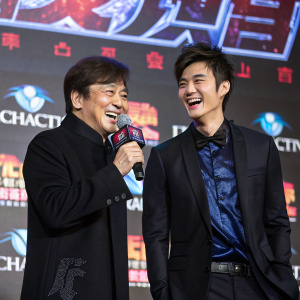 Jackie Chan and Show Luo attending a press conference for 'Bleeding Steel'. Joyful expressions, colorful backdrop with logos and branding elements, stage lighting enhancing vibrant colors, dark suits