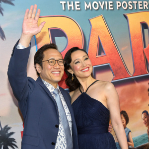 Rob Schneider and Patricia Maya Schneider posing at the premiere. Colorful movie poster backdrop.