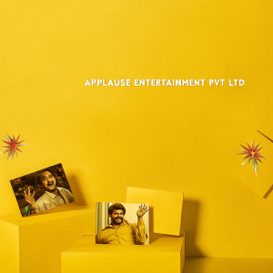 Dynamic promotional ad for Applause Entertainment Pvt Ltd. Featuring vibrant images of diverse characters and scenes from their premium drama series, films, documentaries, and animations. Dark background with bursts of red and other hues from showcased content. Includes info about company offerings and a prominent call-to-action button.