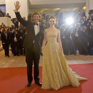 Sam Claflin and Lily Collins walking the Hollywood film festival red carpet. Both in formal attire, posing for cameras.