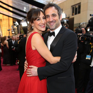 Lindsay Sloane and Dar Rollins, dressed formally, at the Oscars pre-party. They're hugging and beaming for the paparazzi.