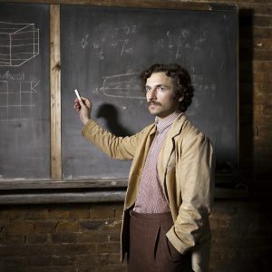 Albert Einstein, intense gaze, holding a chalk in his hand, detailed chalkboard backdrop.