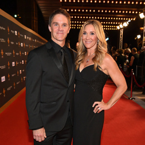 Luc Robitaille and Stacey Toten at the Canadian Screen Awards. Wearing elegant black dresses and suits. Red carpet ambiance.