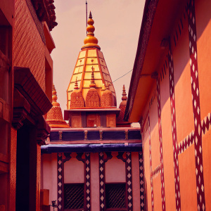 Photorealistic image of Kashi Vishwanath Temple in Varanasi, India. Temple with multi-tiered roof, intricate carvings. Golden spires and vibrant colors. Surrounded by traditional Indian architecture and cultural symbols.
