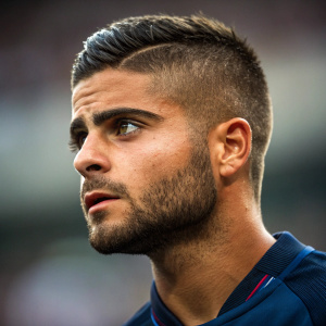 Close-up of Italian footballer Lorenzo Insigne. His intense gaze and short, styled hair are the focus.
