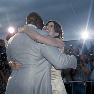 Michael Clarke Duncan and Sandra Bullock, hugging, surrounded by paparazzi and fans at award show.